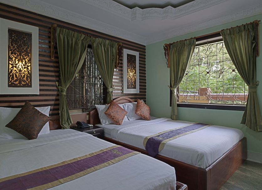 Rs II Guesthouse in Phnom Penh twin room with green curtains and city-view window