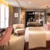 Hôtel Baume in Paris guest room with king bed, pink accents, and upholstered seating