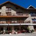 Hostal la Font in Os de Civís, stone chalet-style hotel facade with balconies and terrace seating