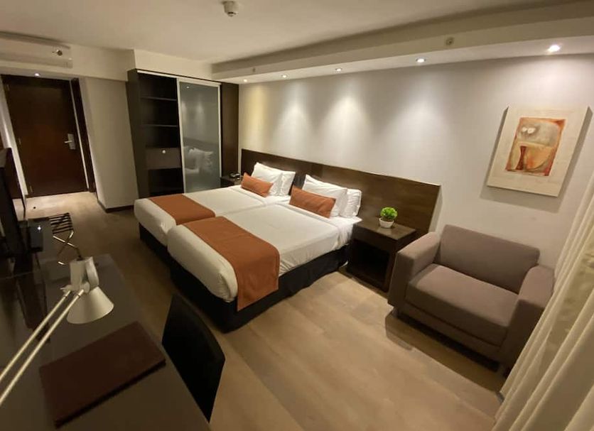Crystal Tower Montevideo guest room with king bed, desk, armchair, and closet