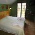 Pousada Atalaia room in Campos do Jordão with double bed, green walls, and balcony doors