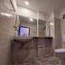 Hotel Sea Coast, Digha bathroom with toilet, sink, mirror and wall-mounted shower