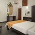 Le Pearl Goa Resort & Spa room in Vagator with bed, TV, desk and stained-glass window