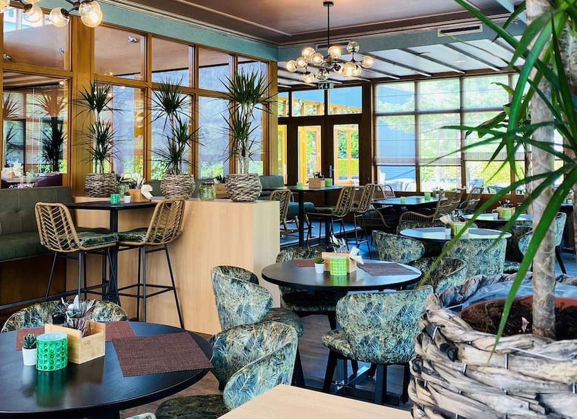 Hotel Schaepkens Van St Fijt lounge and dining area with tables, chairs, and large windows in Valkenburg Aan De Geul