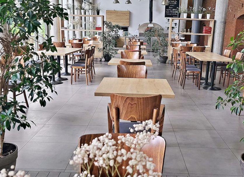 Hotel Forza, Poznan: bright restaurant dining area with wooden tables, chairs and plants