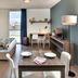 Teneo Apparthotel Bordeaux Maritime room with bed, desk, dining table and city view in Bordeaux