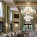 Grand Serai Congress & Spa in Ioánnina ballroom with crystal chandeliers, tall curtains and set dining tables
