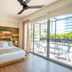 Mayan Monkey Cancun room with colorful wood headboard and balcony overlooking pool area in Cancún