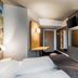 B&B Hotel Bonn-West room with bed, wall-mounted TV, desk, and bunk bed in Bonn