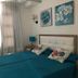 La Venecia de Canarias Puerto de Mogan bedroom with twin beds, teal bedding and floral wall art in Mogán