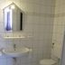 Hotel Am Markt, Eckartsberga bathroom with sink, mirror, toilet and tiled walls