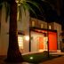 Oporto Hotel Boutique in Santiago, lit entrance with palm tree and red canopy at night
