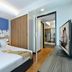 Citadines Sukhumvit 11 Bangkok bedroom with king bed, city skyline mural, and kitchenette view