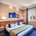 Hotel Diocleziano Rome guest room with king bed, desk and city-view windows