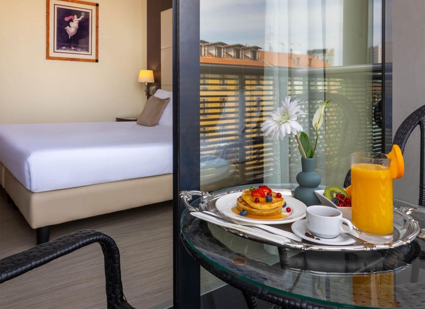 iH Hotels Milano Watt 13 Milan guest room with balcony breakfast tray and city view