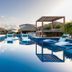Grand Windsock Bonaire in Kralendijk with a serene pool, lounge chairs, and cabanas reflecting in water