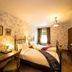 Rokeby Manor in Invergarry, cozy twin bedroom with floral wallpaper, wooden desks, and window view