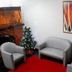La Defense Apart Hotel in Montes Claros lounge with gray chairs, red carpet, and abstract wall art