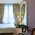 Le Dokhan's, Paris Arc de Tiromphe, a Tribute Portfolio Hotel guest room with striped bed and window drapes