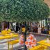 Pullman Toulouse Airport in Blagnac, outdoor terrace with yellow tables, chairs and a shaped tree