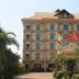 Majestic Oriental Hotel in Siem Reap with grand facade, flags, and palm-lined entrance