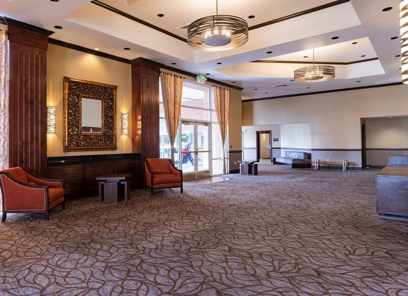 Hampton Inn & Suites Salt Lake City Airport lobby with patterned carpet, seating area, and large windows