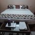 Goroomgo Mourya Inn Madhya Pradesh in Harda, simple bedroom with double bed, pillows and tray table