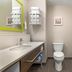Hampton Inn Junction City bathroom with vanity, toilet, tub-shower, and towel shelves