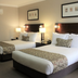 Carlyle Suites and Apartments in Wagga Wagga twin room with two beds, lamps, and framed wall art