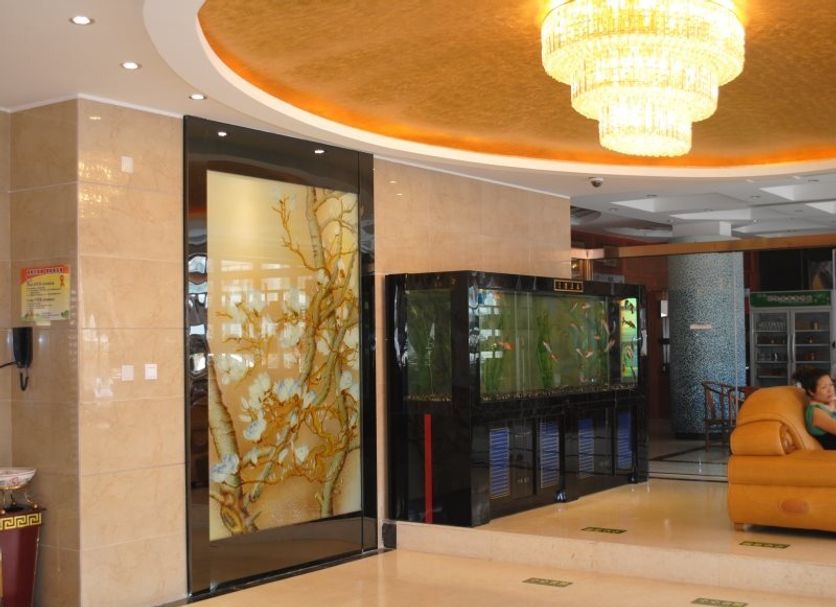Yiwu Mango Hotel in Jinhua lobby with chandelier, decorative glass doors and seating area