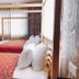 Hotel Duomo And Suites in Kampala: twin canopy beds with red patterned bedspreads in a hotel room