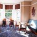 New Wilmington Hotel Eastbourne dining room with bay windows, patterned carpet, and tables set for guests
