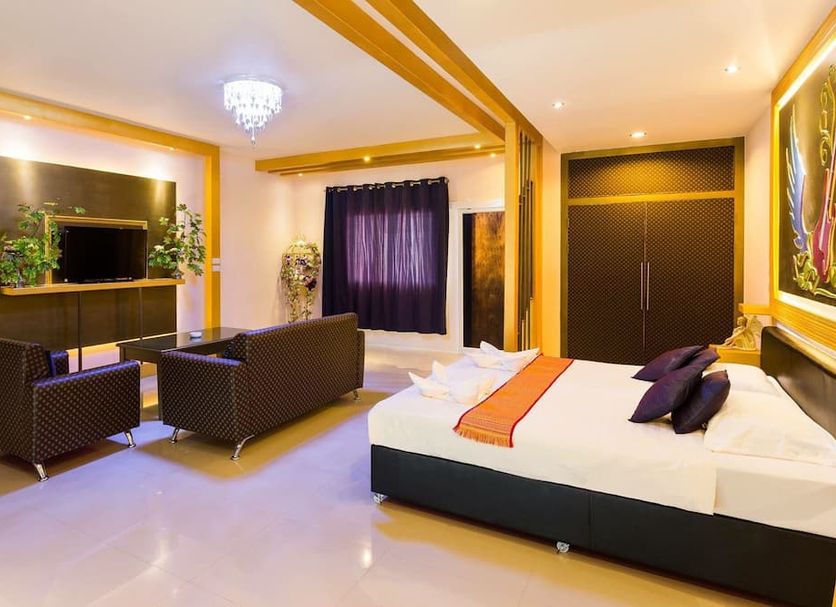 Marble Garden View Pattaya guest room with bed, seating area, TV, and large window in Pattaya
