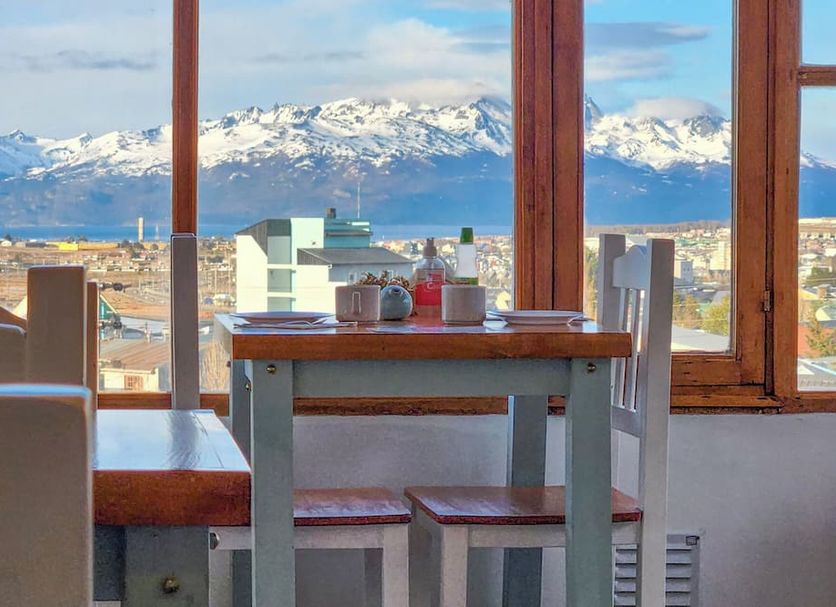 Hosteria Aonikenk in Ushuaia with dining table and snowy mountain view through large windows
