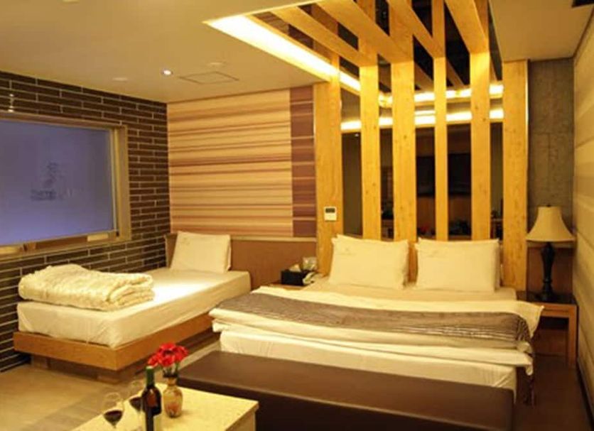Goryeo Hotel in Andong guest room with two beds, warm wood accents, and bedside lamp