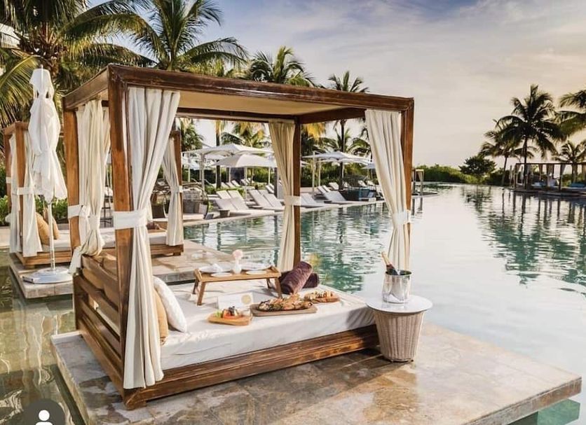 TRS Coral Hotel - Adults Only in Cancún: beachfront cabana beside a serene pool with palm trees