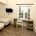 Airport Motel & Apartment in Gardermoen guest room with three beds, desk, wall-mounted TV and window