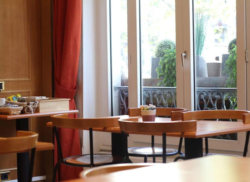 Hotel Cosmotel, Paris breakfast room with tables beside glass doors and a small balcony view