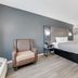 Quality Inn Laurinburg guest room with king bed, chair, desk, and vanity area