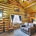 Hibernation Station in West Yellowstone log cabin guest room with king bed, sofa, and wood-paneled walls