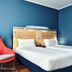 Holiday Inn Express Milan - Malpensa Airport room with twin beds and red chair in Somma Lombardo