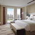 Langham Place, Xiamen guest room with king bed and city skyline view through tall windows