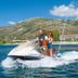 Golden Coast Hotel & Bungalows in Marathon with guests riding a jet ski on the sea near mountains