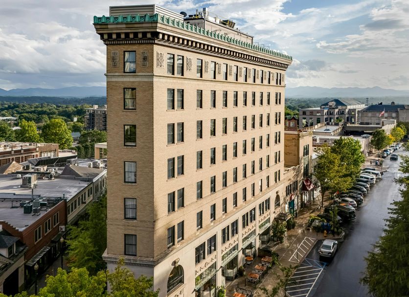 The Flat Iron Hotel in Asheville, tall historic building on a city street with mountain views