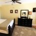 Princess Anne Hotel Asheville guest room with ornate four-poster bed, dresser, and ceiling fan