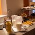 Hotel Balneari Prats breakfast buffet with pastries, cereal and milk on a checkered tablecloth in Caldes de Malavella
