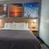 Bay Inn Tawas City guest room with king bed, bedside lamps, and wall art
