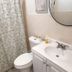 La Mare Fort Lauderdale Airport bathroom with shower curtain, toilet, sink and round mirror in Fort Lauderdale