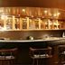 Himgiri Resorts in Dharamshala bar with wooden stools, backlit glass cabinets and a curved counter