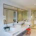 Pace Hotel Suzhou Renmin Road bathroom with double sinks, large mirror, glass shower and toilet in Suzhou